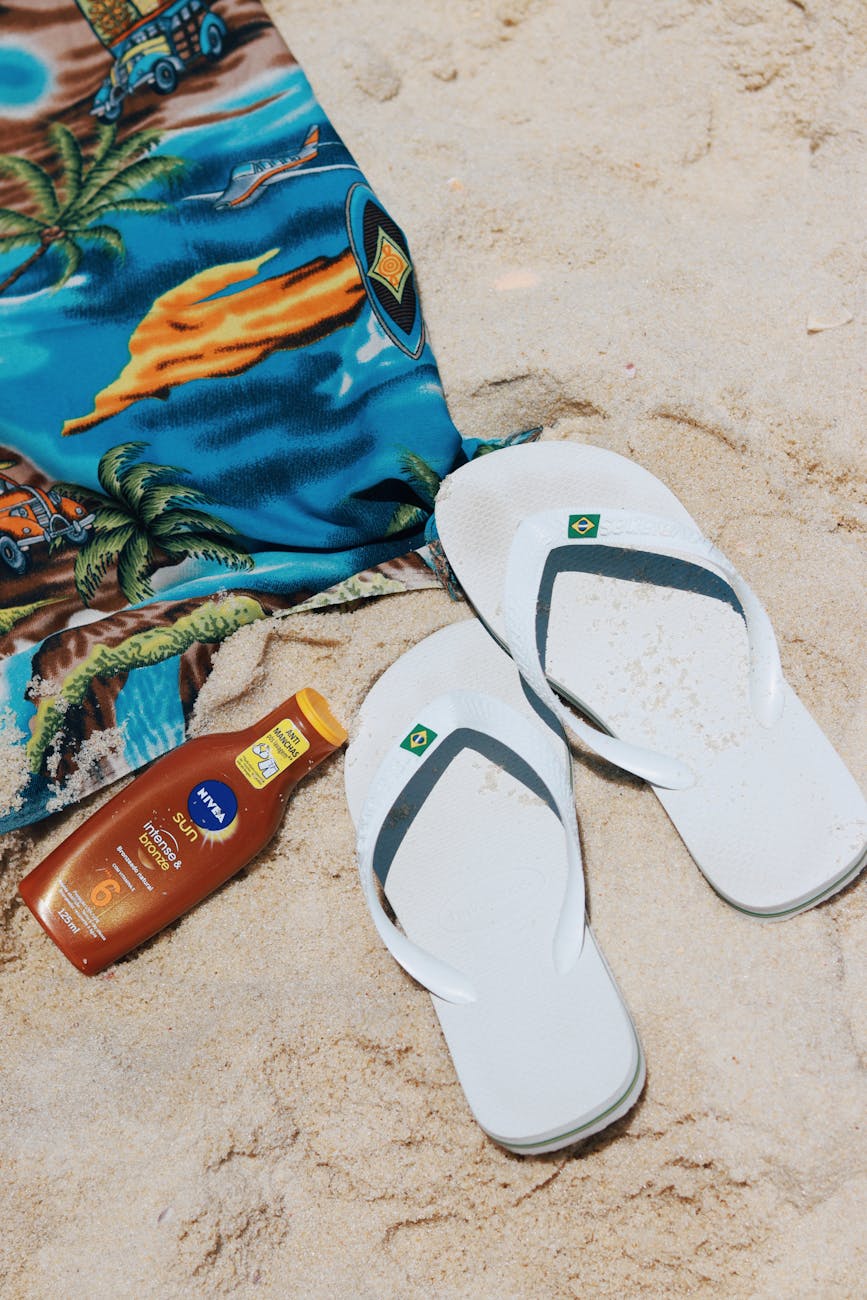 flip flops towel and a sunscreen on the beach